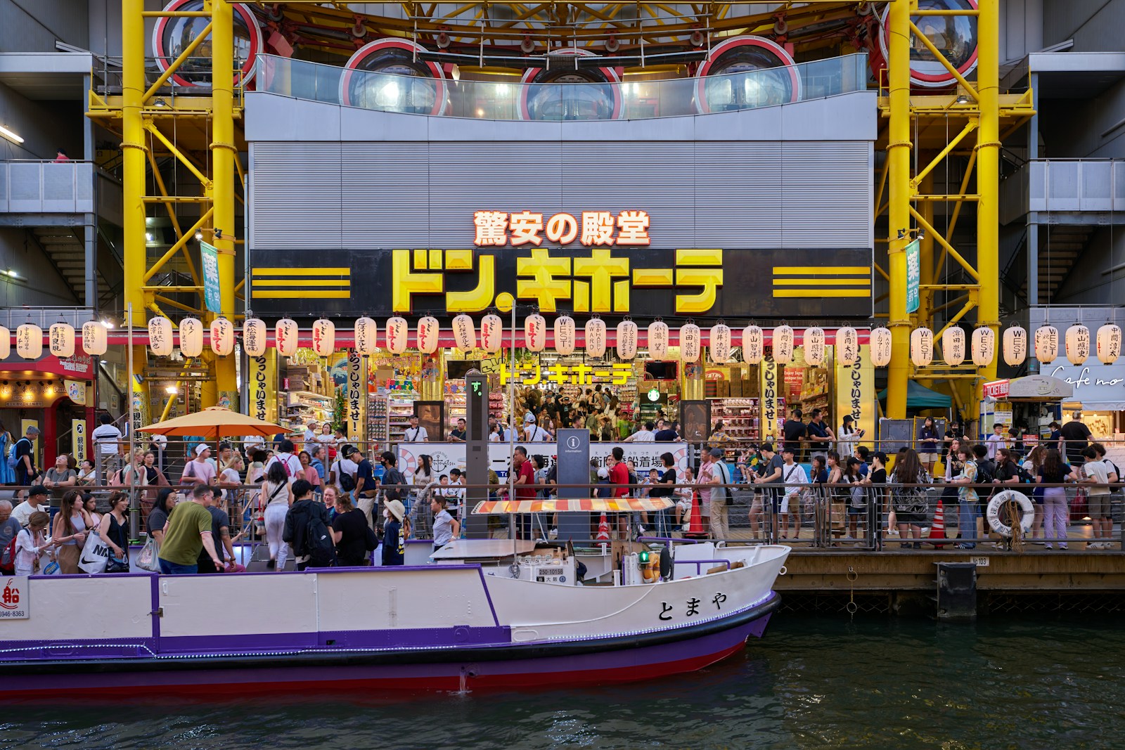 A group of people standing on top of a boat in a body of water