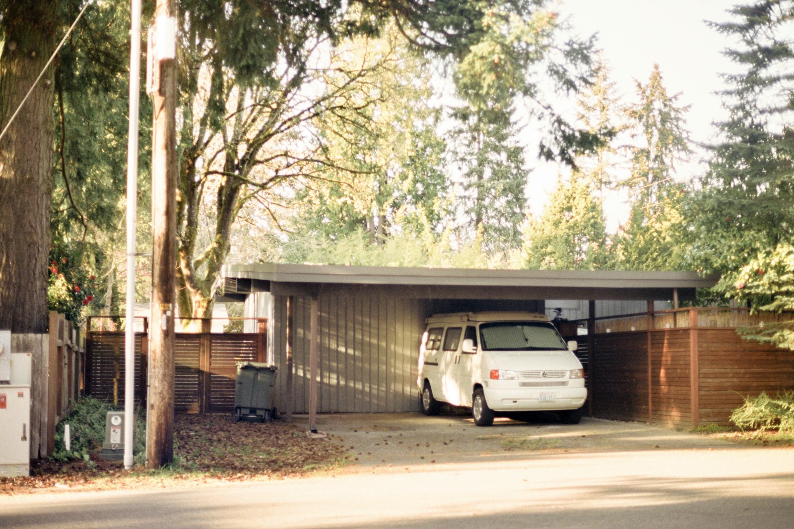 white car parked near brown wooden fence during daytime